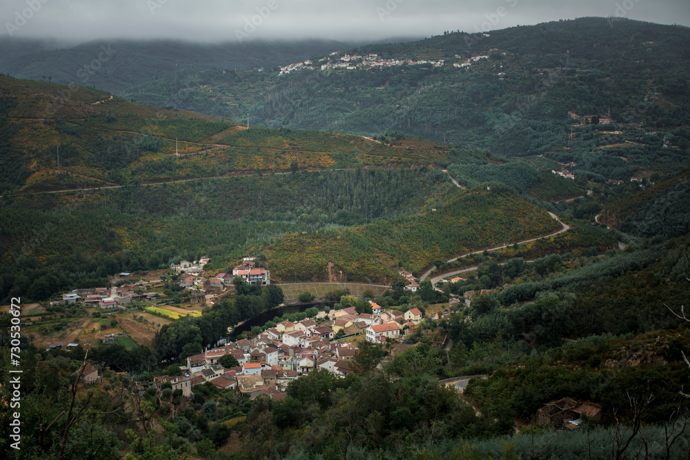 A town on a misty morning at the foot of the Serra da Estrella mountains in Portugal.