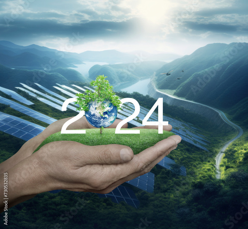 2024 with planet and tree on green grass in hands over solar photovoltaics cell farm on mountain, Happy new year 2024 ecological cover, Save the earth concept, Elements of this image furnished by NASA