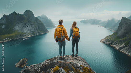 A couple on a cliff edge in Norway Lofoten Islands, Couple family traveling together on cliff edge in Norway man and woman lifestyle concept summer vacations outdoor aerial view Lofoten islands