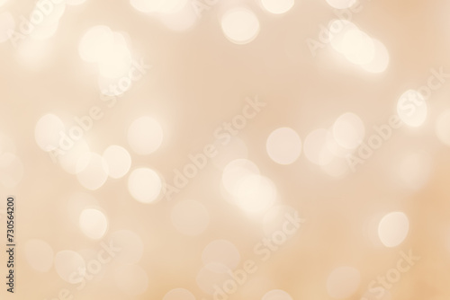 Defocused abstract bokeh background beige pastel colored, flare from lights, beige monochrome photo, blurred round bokeh as holiday fon, celebration wallpaper. Glittering aesthetic pattern