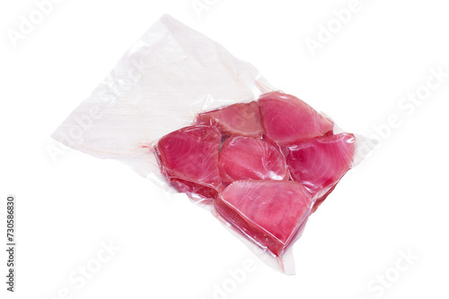 vacuum-packed tuna steaks on a light wooden surface