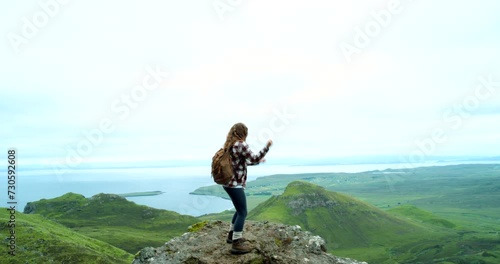 Woman, dancing and hiking on mountain, trail and outdoor for freedom and adventure in nature. Female, tourist and view from vermont, hills and holiday vacation with high energy for wellness and peace photo