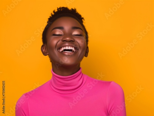 Vibrant image of a cheerful young African women laughing heartily, wearing a pink turtleneck against a vivid yellow backdrop.