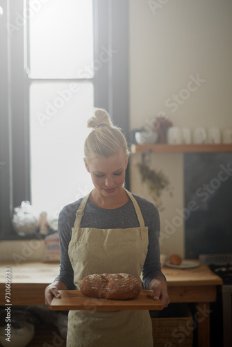 Bakery, kitchen and woman with bread on tray for cooking with healthy gluten free food for breakfast. Fresh, loaf and chef in restaurant with rye or sourdough for brunch, meal or lunch with nutrition
