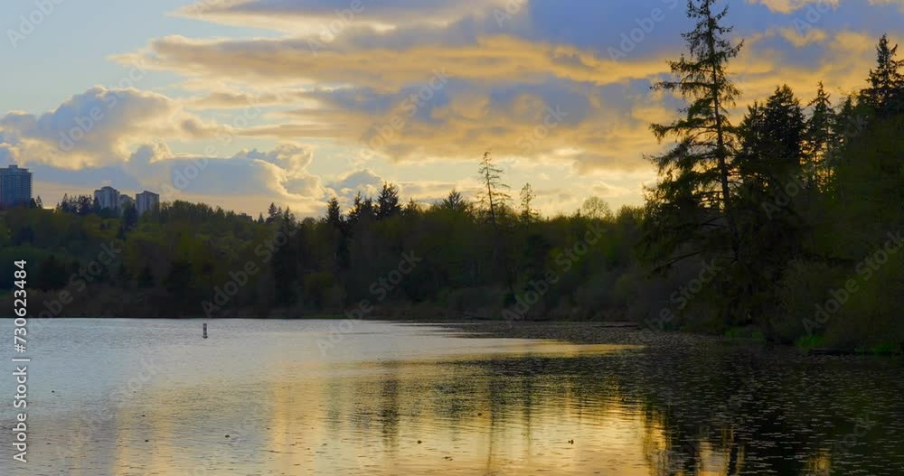 Establishing shot of lake sunset in slow motion at summer day in Vancouver, Canada, North America. Evening time on September 2023. Still camera. ProRes 422 HQ. Establishing shot of lake sunset in slow motion at summer day in Vancouver, Canada, North America. Evening time on September 2023. Still camera. ProRes 422 HQ.