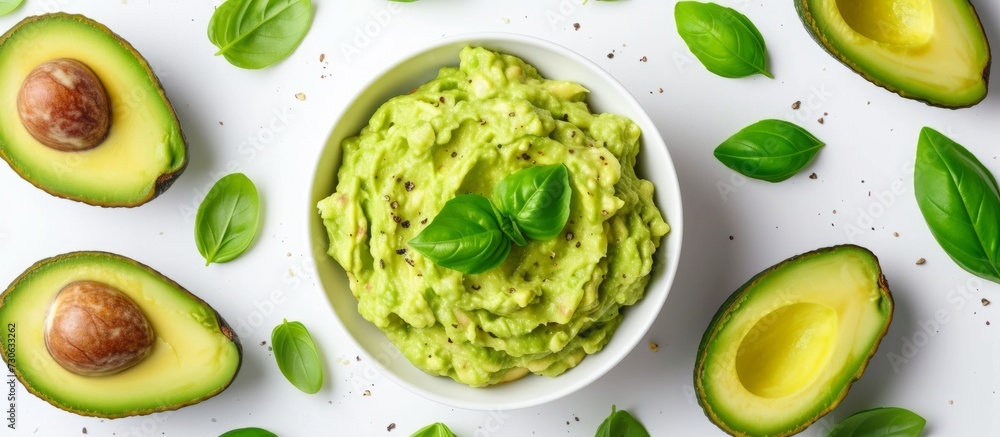 Top view of a delicious guacamole bowl with basil and avocados on a white background. Top view of a delicious guacamole bowl with basil and avocados on a white background.
