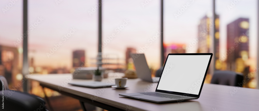 Close-up image of a laptop computer on a meeting table in a modern company meeting room. Close-up image of a laptop computer on a meeting table in a modern company meeting room.