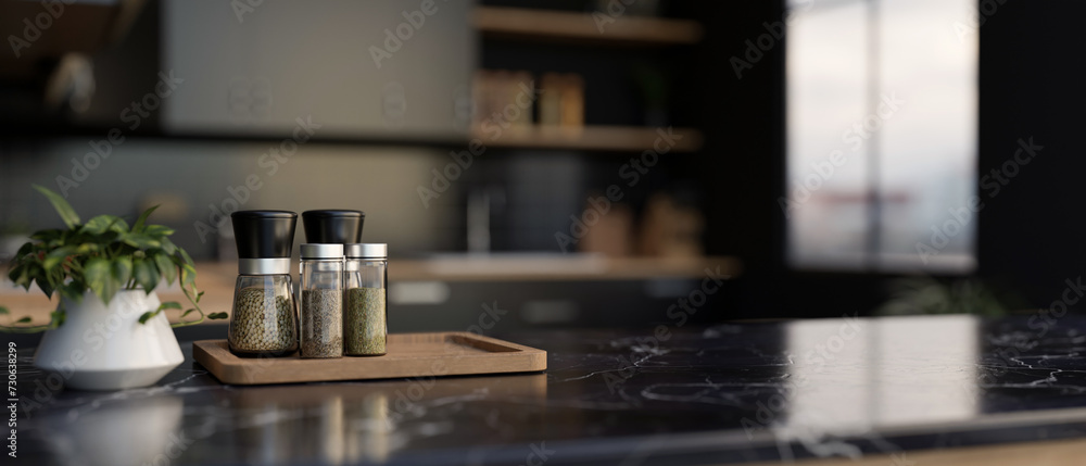 A set of spice bottles on a luxury black marble kitchen countertop in a modern black kitchen. A set of spice bottles on a luxury black marble kitchen countertop in a modern black kitchen.