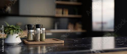 A set of spice bottles on a luxury black marble kitchen countertop in a modern black kitchen.