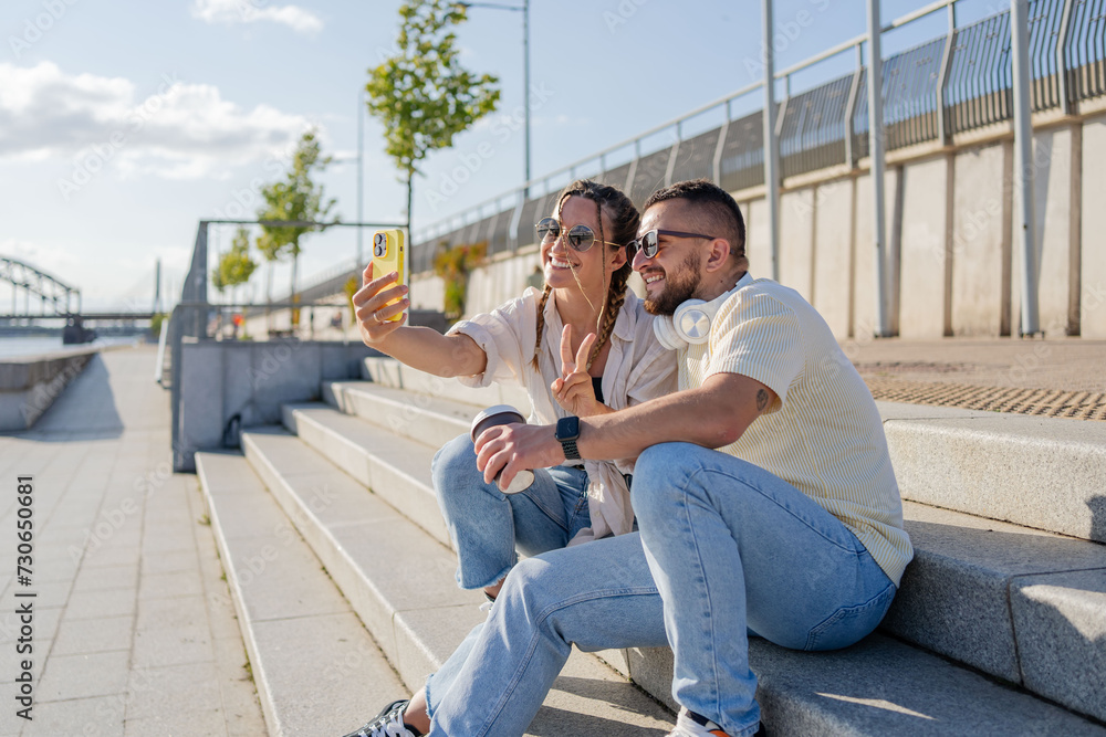 Fototapeta premium couple in the city to relax, smile and be happy together in summer. Portrait of an urban and interracial man and woman. Smile, happy guy and woman or student fashion friends.