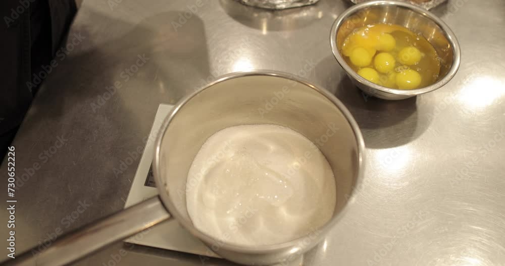 Close up of sugar in a steel syrup pot to melt it over the fire to make syrup. Dessert ingredients for confectionery. Close up of sugar in a steel syrup pot to melt it over the fire to make syrup. Dessert ingredients for confectionery.
