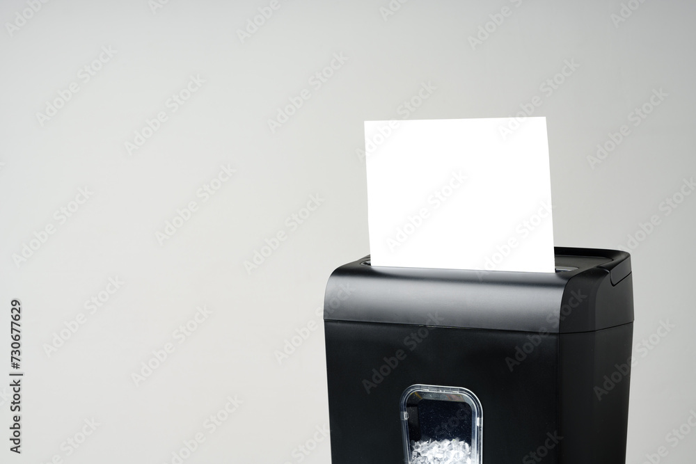 Office paper shredder on table against gray background Office paper shredder on table against gray background