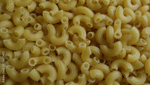 Raw pasta macaroni pipe rigate top view background