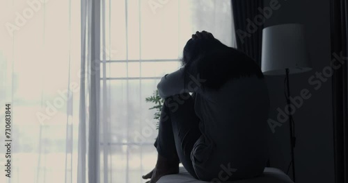 Atmosphere of depression, Trouble in relationship, death in the family. Sad young woman in the living room of her home, Covering face with hands.  Dramatic bad news cinematic slow motion moment. photo