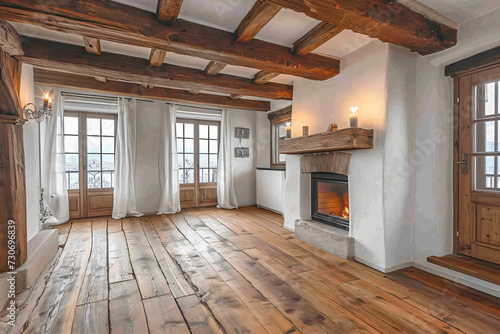 White room with wooden flooring and ceiling beams. fire place on right.