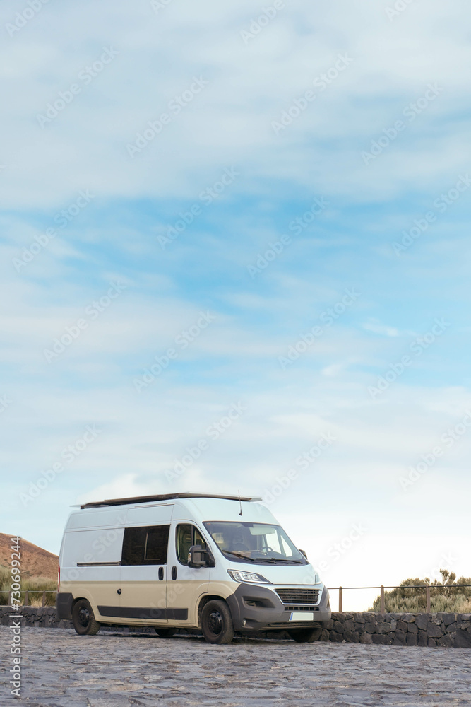White Van Parked on a Cobblestone Road Surrounded by a Natural Landscape