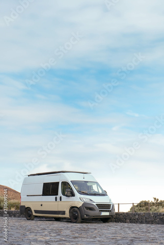 White Van Parked on a Cobblestone Road Surrounded by a Natural Landscape