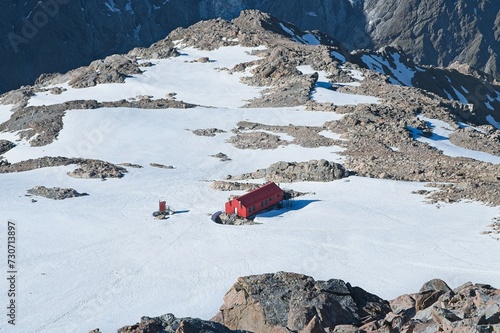 Cozy Red Cabin Amidst Snowy Wilderness: Mueller Hut Nestled in New Zealand's Spectacular Mountain Terrain