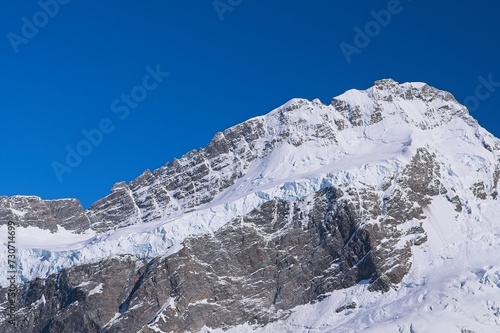 Icy Mountain Close-Up: Stunning Snow-Covered Peaks Against a Vibrant Blue Sky