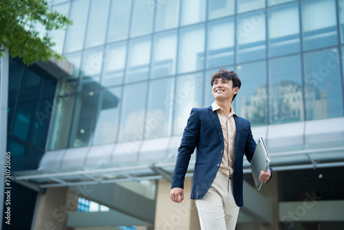 Portrait of young Asian businessman outside