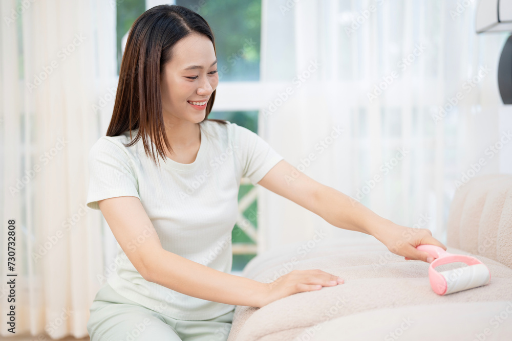 Young Asian woman cleaning sofa Young Asian woman cleaning sofa