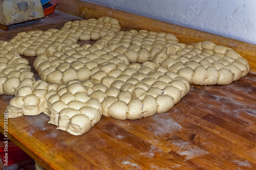 Fresh bread dough resting at wooden table in bakery.