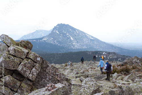 Adventurous hikers on breathtaking rocky mountain top, enjoying stunning valley and peak views