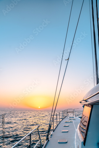 A beautiful sailing yacht sailing in sea with sunset