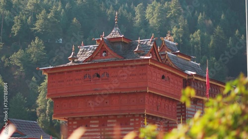 Closeup shot of wooden BhimaKali Temple at Sarahan in Himachal Pradesh, India. Old Hindu temple in front of pine trees on top of the mountains.Hindu Religious temple in the Himalayan mountains.	 photo