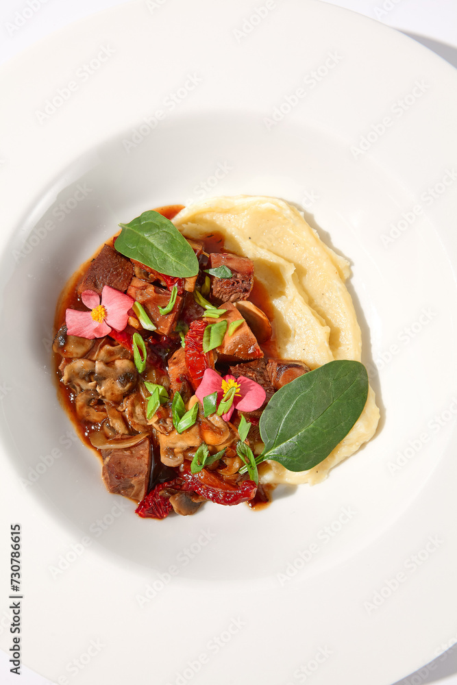 Braised beef with vegetables and mushrooms, topped with mashed potatoes on a white background, top view - perfect for comfort food menus Braised beef with vegetables and mushrooms, topped with mashed potatoes on a white background, top view - perfect for comfort food menus