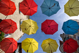 CITY LANDSCAPE - Tenement houses and colorful umbrellas against the blue sky
