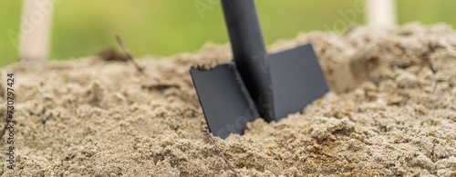 Spatenstich Neubau Spaten im Sand auf einer Baustelle