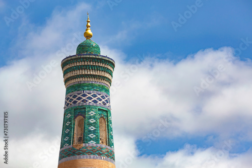 Islam Khoja Minaret in Khiva, Uzbekistan. Best viewpoint at Ichan Kala (ancient city of Khiva). Close up fragment, Blue sky, copy space photo