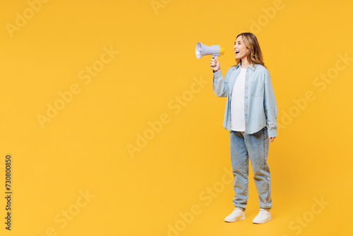 Full body young woman wear blue shirt white t-shirt casual clothes hold in hand megaphone scream announce discounts sale Hurry up isolated on plain yellow background studio portrait Lifestyle concept