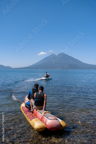 Young Hispanic Men Tubing on Airhead Hot Dog in Atitlan Lake, Guatemala