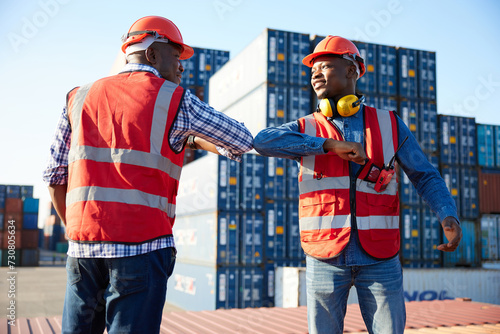 African factory workers or engineer greeting with elbow bumps in containers warehouse storage photo