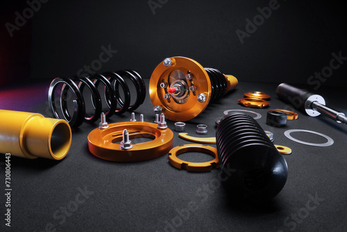 suspension tuning, coilovers, shock absorbers and front springs in yellow and gold colors for a sports drift car on a dark background	 photo