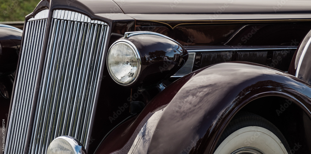 very old black classic car detail from front and lights panorama