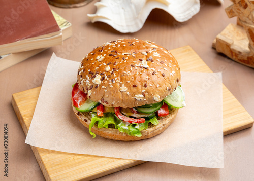 Sandwich, vegan burger in a cereal bun on a wooden board.