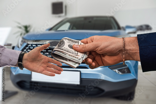 Two businessmen shake hands  buy or rent new auto in modern car showroom.