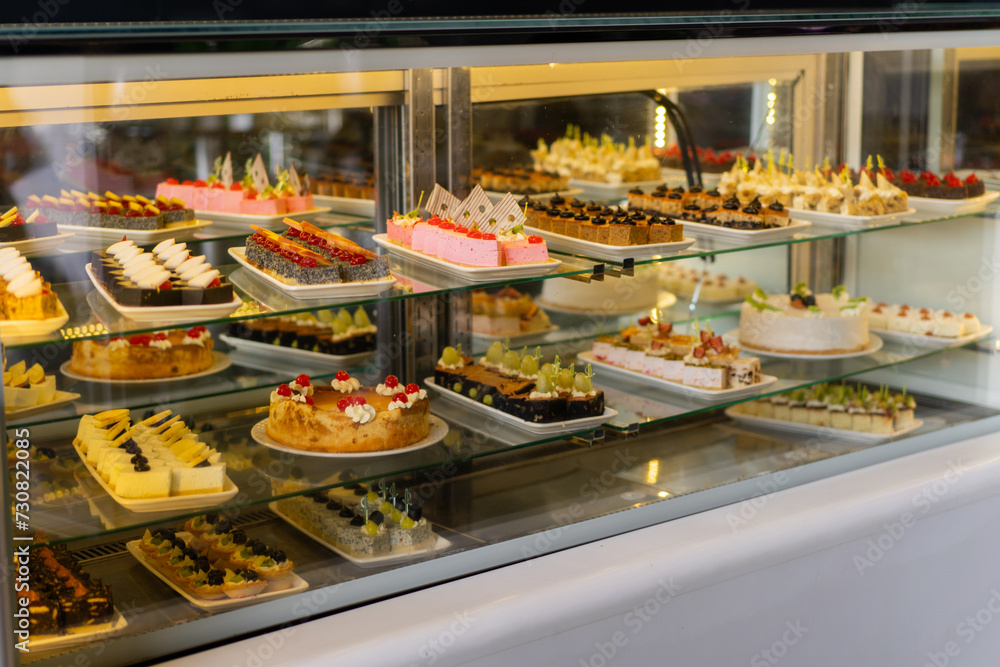 Showcase with sweets, Various desserts and cakes for sale in the pastry shop. Glass display at store bakery pastry shop.