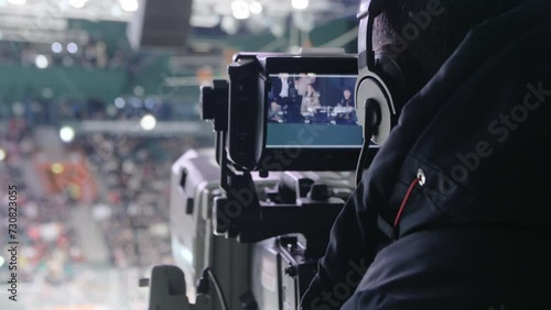 Professional operator adjusts focus to ensure crystal clear in footage. Operator maneuvers camera to follow fast-paced movements of players photo