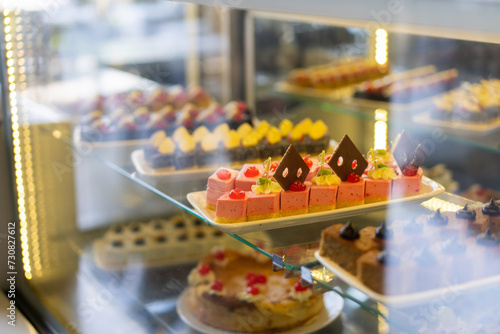 Showcase with sweets, Various desserts and cakes for sale in the pastry shop. Glass display at store bakery pastry shop.