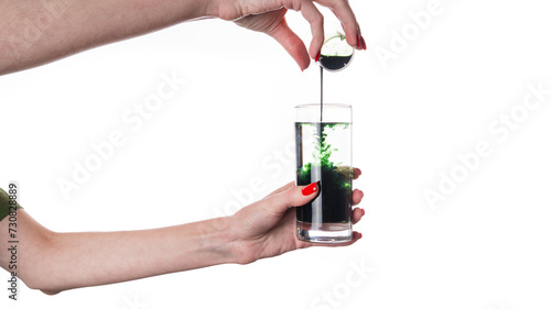 Liquid Chlorophyll in a Glass of Water in hand, Superfood, Healthy Eating, Detox and Diet Concept photo