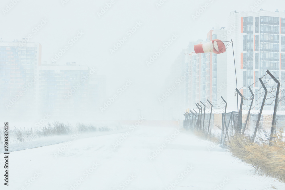 A snowstorm. People walk down the street during a snowstorm. Heavy snowfall. against the background of a cold urban landscape. A snowstorm. People walk down the street during a snowstorm. Heavy snowfall. against the background of a cold urban landscape.