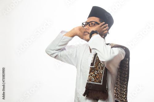 Brown skinned Asian Muslim man is giving the call to prayer for Muslims to worship, muezzin man concept