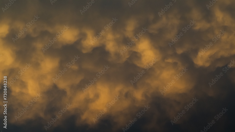 Ciel jaunâtre pendant le coucher du soleil, sous des nuages de type mammatus, après un orage - obrazy, fototapety, plakaty 