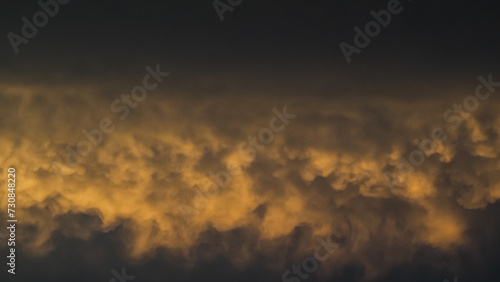Ciel jaunâtre pendant le coucher du soleil, sous des nuages de type mammatus, après un orage photo