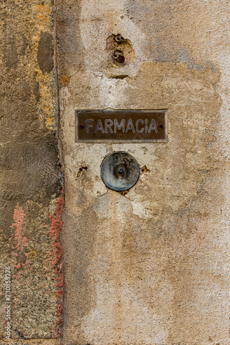 Farmacia in Italian, or Pharmacy in English old plate on decaying wall, ringer button, shallow focus, mailbox on the wall, Seggiano city, Grosseto province,  Tuscany region, Italy, Europe, EU photo