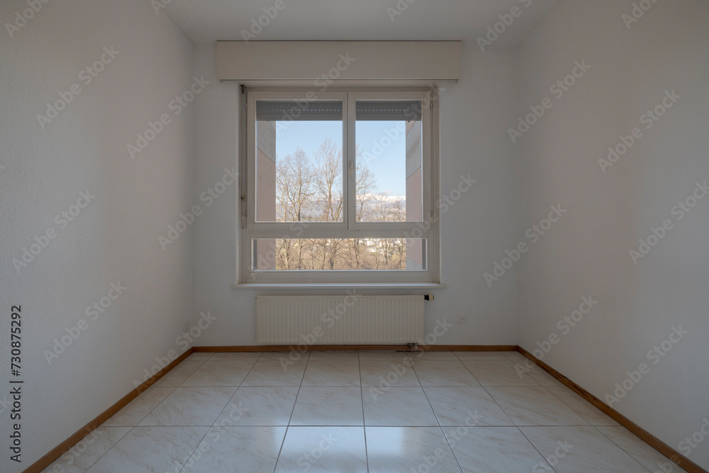 Fototapeta premium Front view of an empty room with windows overlooking nature.